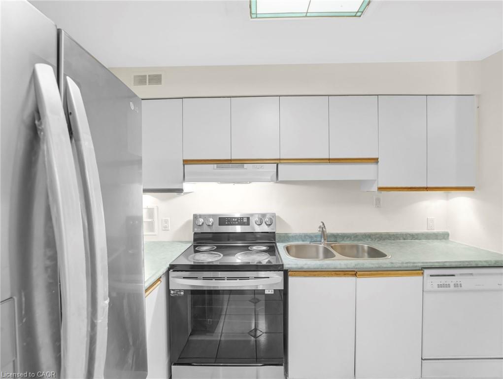Kitchen featuring white cabinetry, stainless steel refrigerator, stainless steel electric range, double basin sink, and a dishwasher
