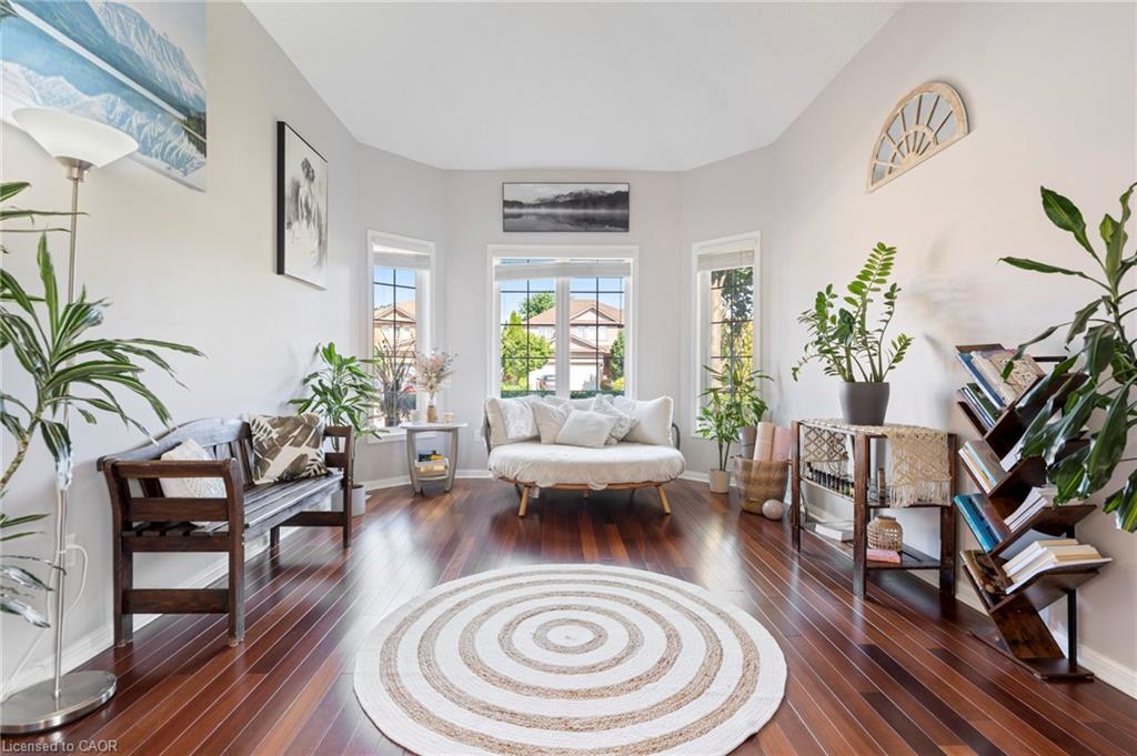 Bay window with multiple panes, rich wood-finish flooring, light-toned wall paint, and recessed ceiling lighting
