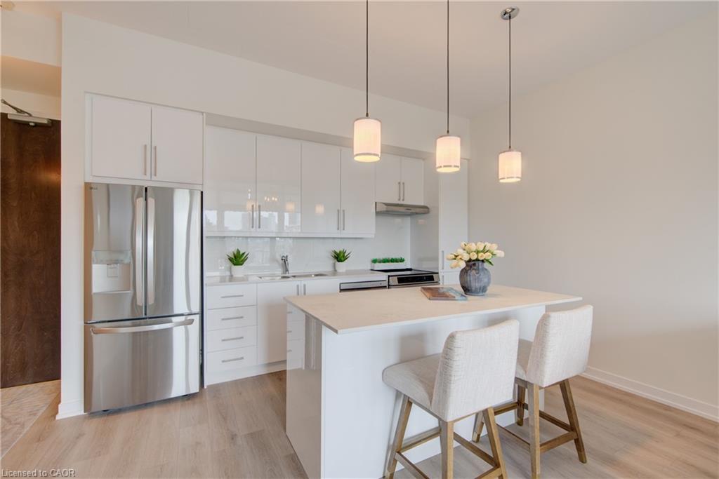 Contemporary kitchen featuring white cabinetry, a large stainless steel refrigerator, white countertops, and a white subway tile backsplash