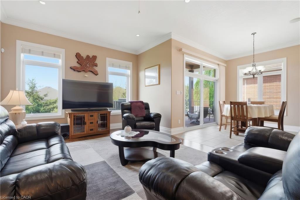 Recessed lighting, crown molding, multiple windows, sliding glass door, and a dining area with a chandelier
