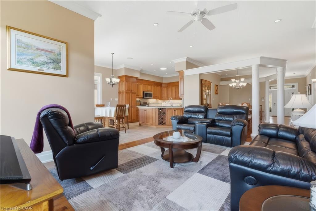 Open-concept living area featuring a ceiling fan, recessed lighting, and a kitchen with wood cabinetry