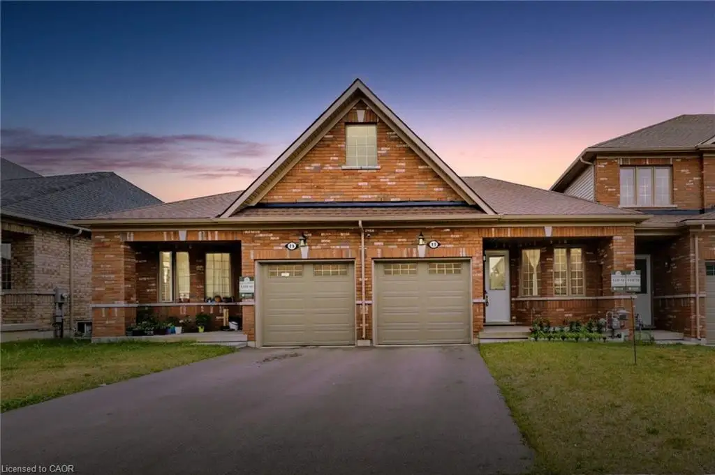 Brick exterior featuring a gabled roofline, two single-car garages, and covered front entrances