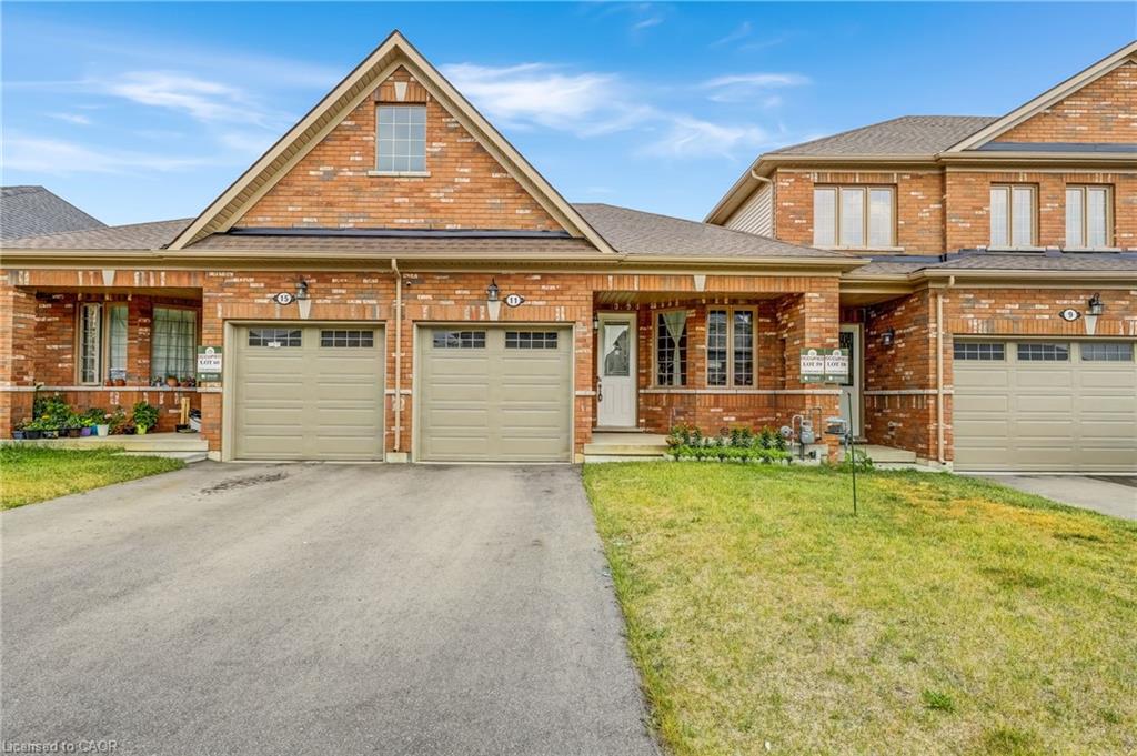 Brick exterior with an attached garage, covered front porch, and an asphalt driveway