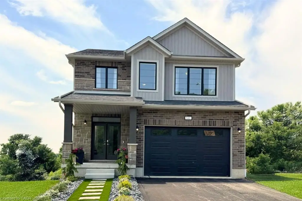 Two-story residence featuring a brick and stone facade, a covered front entry with double doors, and a dark-toned garage door