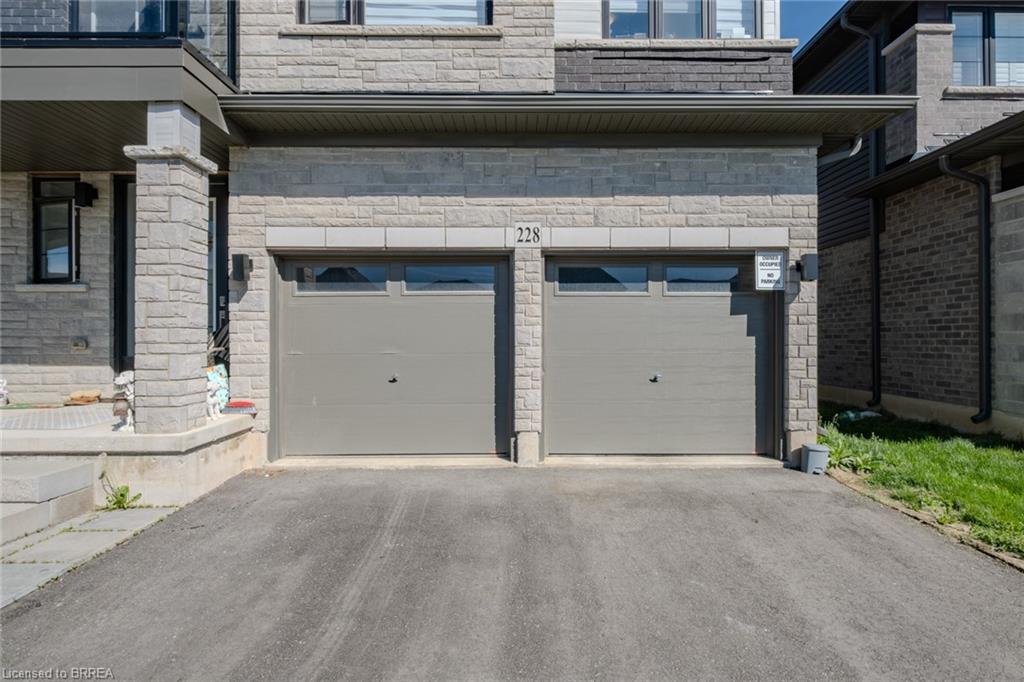 Stone facade with a double-car garage featuring individual doors and transom windows