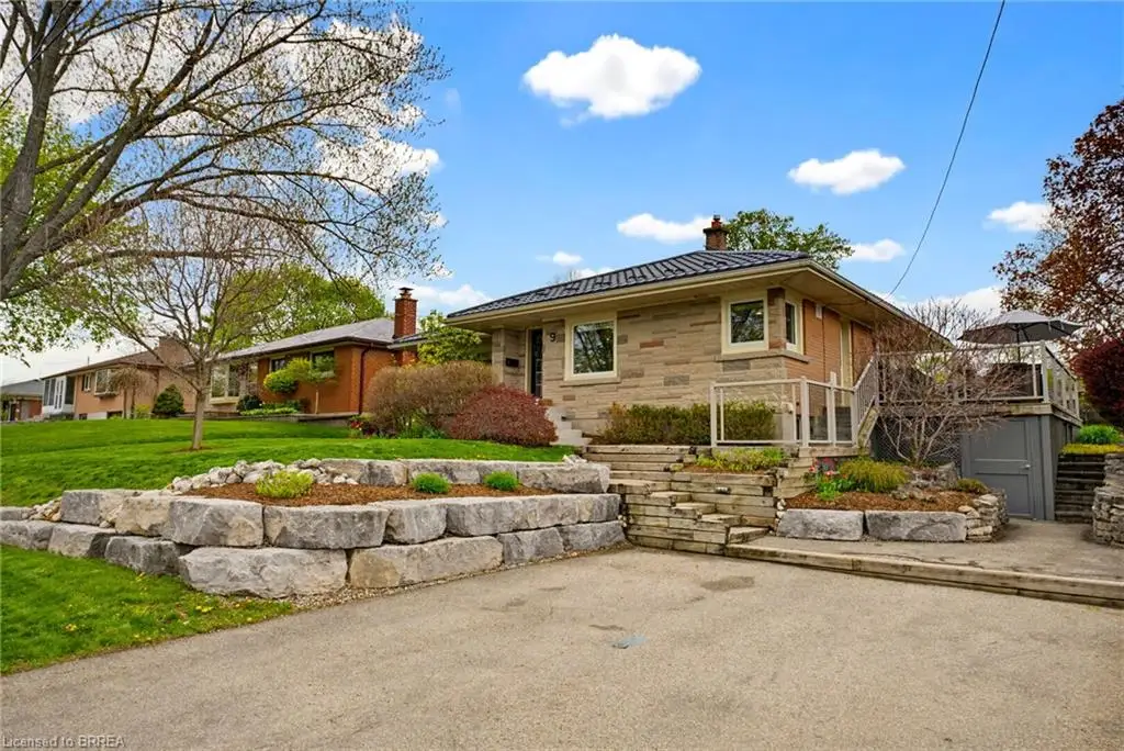 Stone facade residence featuring a dark-tiled roof