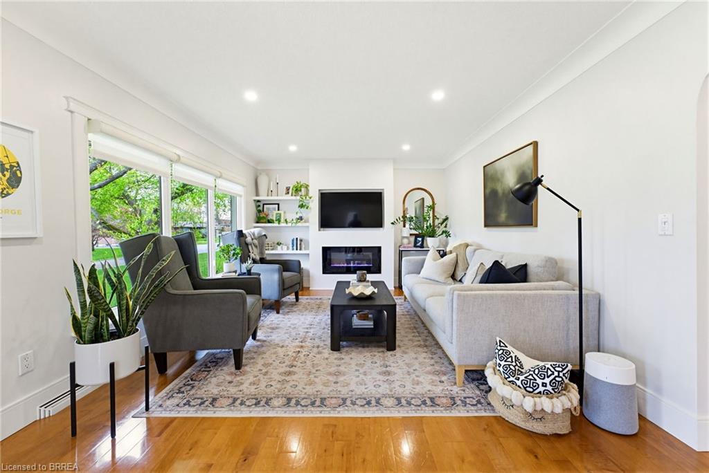 Bright living space featuring warm wood-finish flooring, recessed lighting, and expansive windows