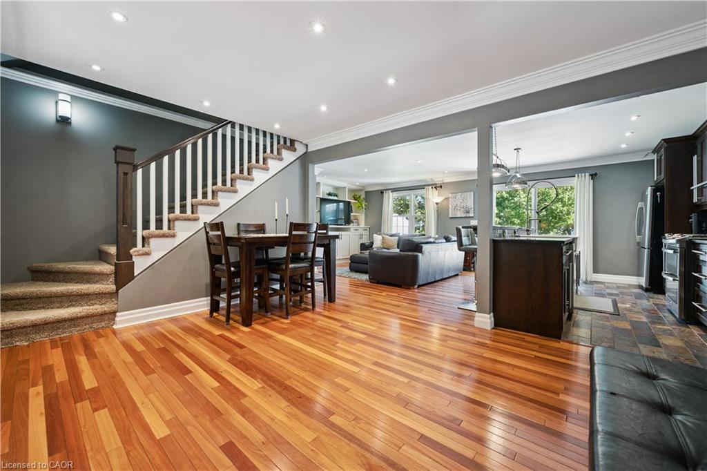 Hardwood flooring throughout, recessed lighting, crown molding, and a staircase with white spindles and a dark wood handrail