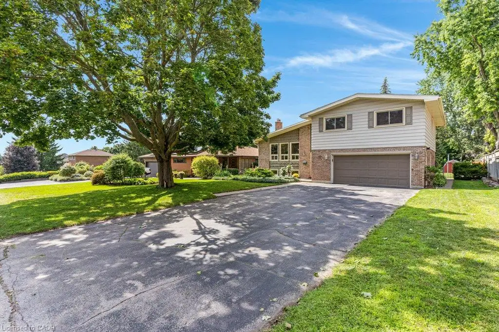 Split-level residence featuring brick and siding exterior, an attached garage, and a paved driveway