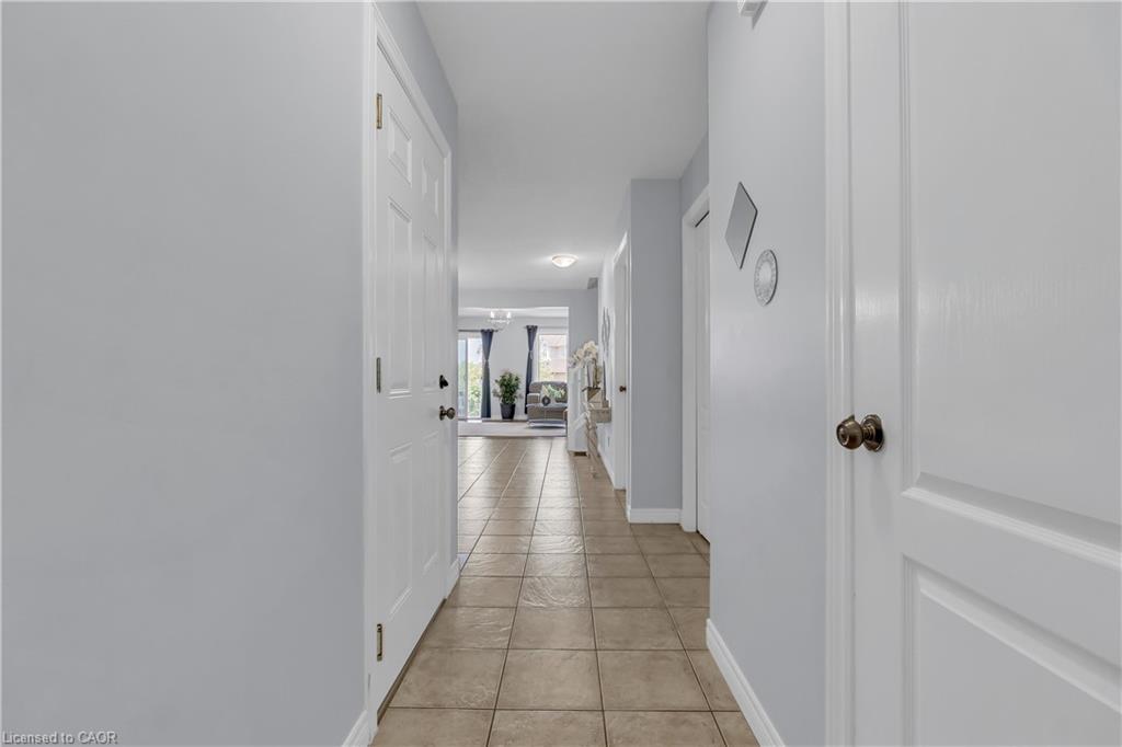 Hallway with neutral tone tile flooring and light-colored walls