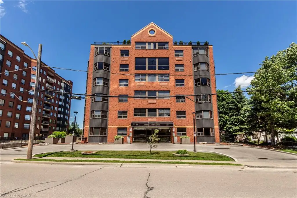 Multi-story brick exterior building featuring dark-toned bay windows, a gabled roofline with a circular window accent, and a prominent ground-level entryway