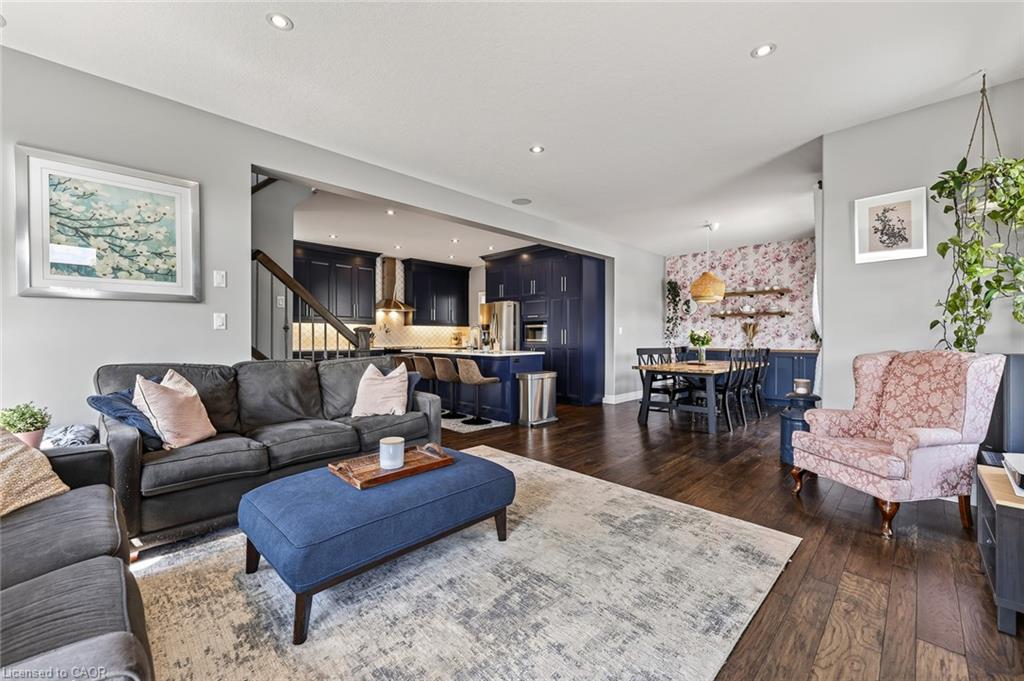 Open-concept living space featuring wood-finish flooring throughout, recessed ceiling lighting, and a neutral wall color