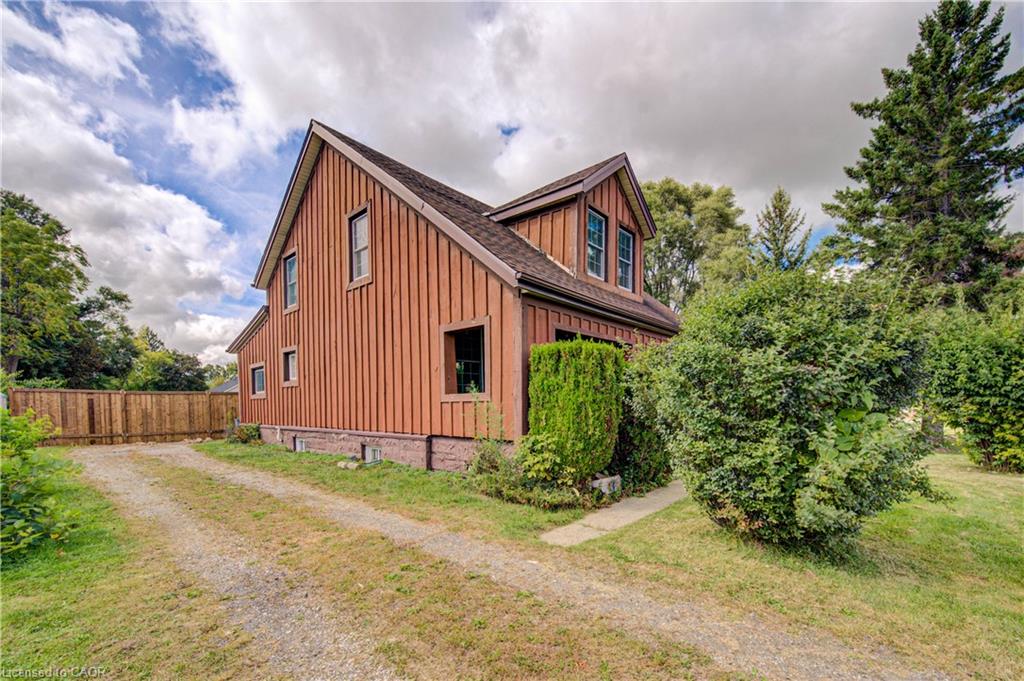 Board and batten siding, multiple windows, a dormer, and a gravel driveway
