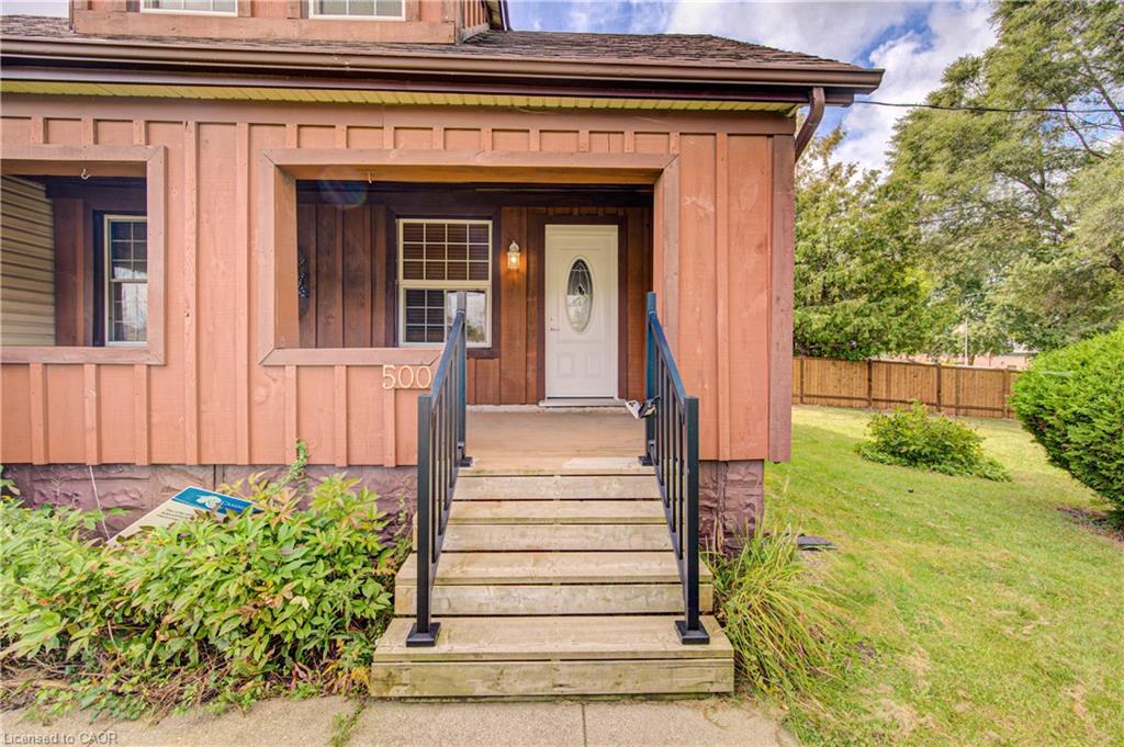 Covered porch entry featuring wood siding and a white oval-lite door