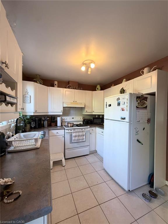 Kitchen featuring white cabinetry, tile flooring, and a built-in oven with cooktop