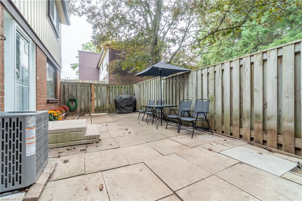 Paved patio area, wood privacy fence, exterior brick and siding, and outdoor air conditioning unit