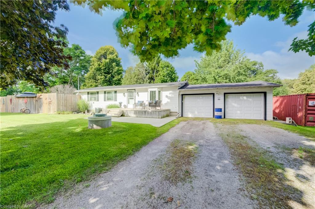 Ranch-style residence with white siding, a two-car attached garage, and a gravel driveway