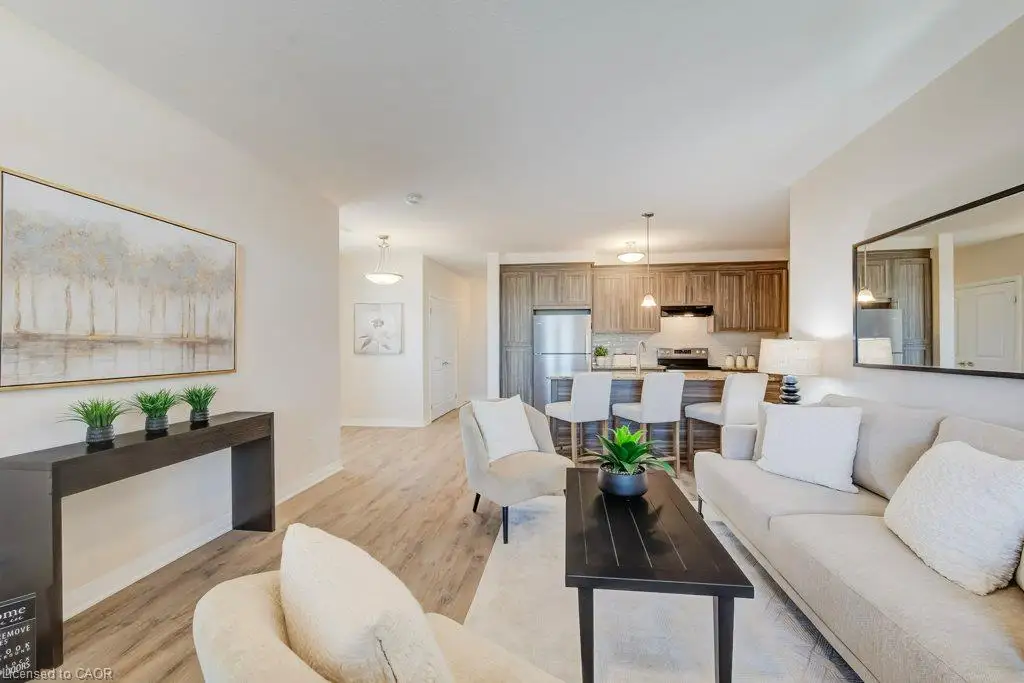 Open-concept interior featuring wood-finish flooring, shaker-style cabinetry, and a kitchen island with built-in counter seating