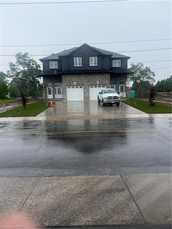 Contemporary multi-unit dwelling with a dark siding upper level and stone facade lower level