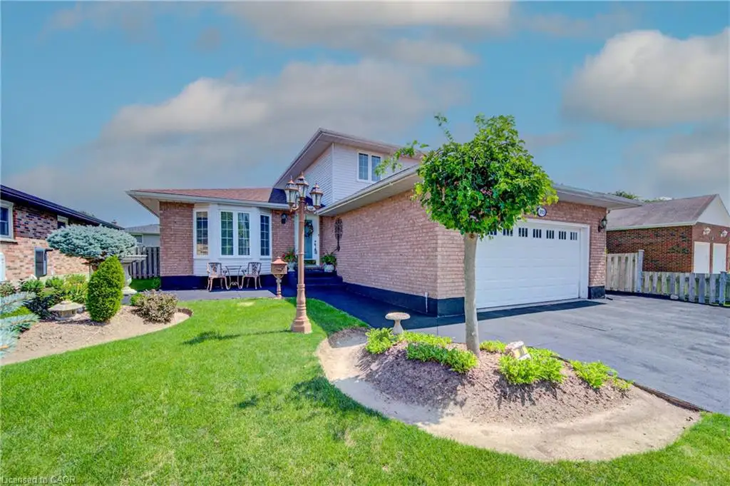 Brick exterior with an integrated two-car garage, bay window, landscaped front yard, and paved driveway