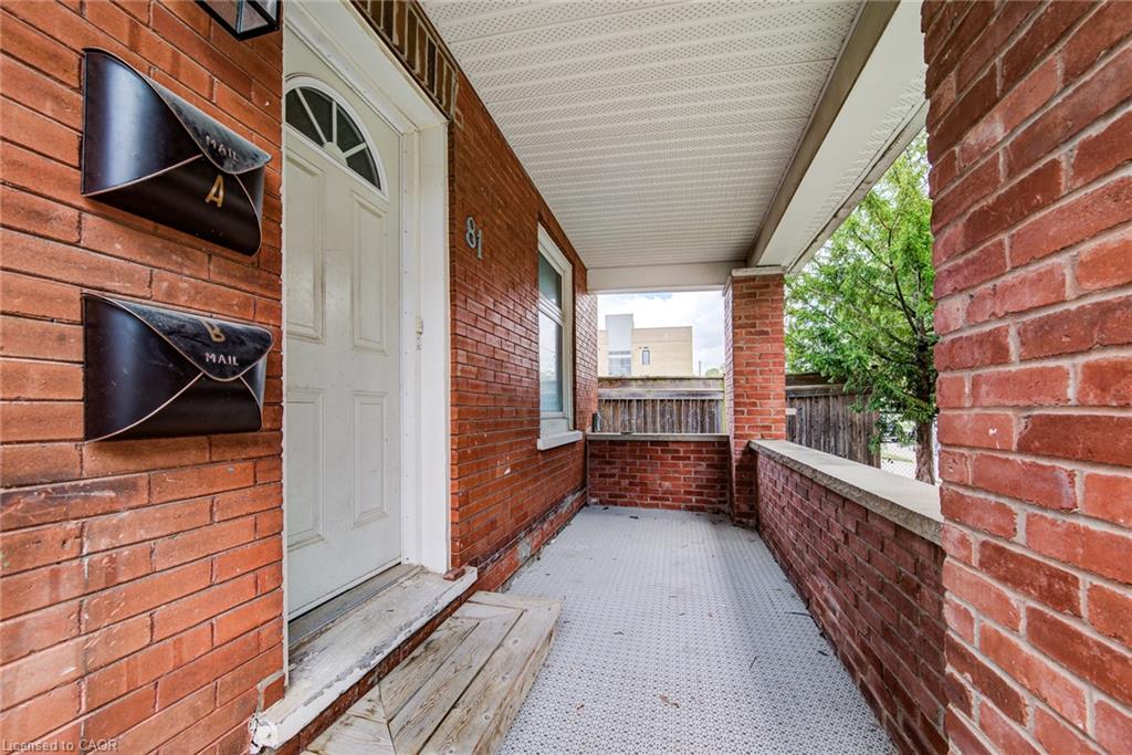 Brick exterior with a covered porch, white entry door, and two wall-mounted mailboxes
