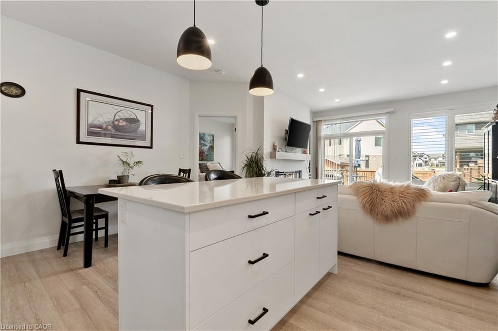 Spacious kitchen island with white cabinetry and a light-toned countertop, featuring two pendant light fixtures