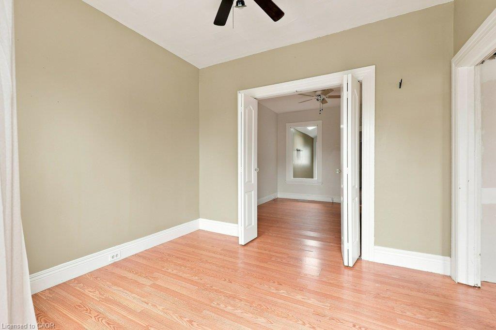 Wood-finish flooring, white trim, and a ceiling fan