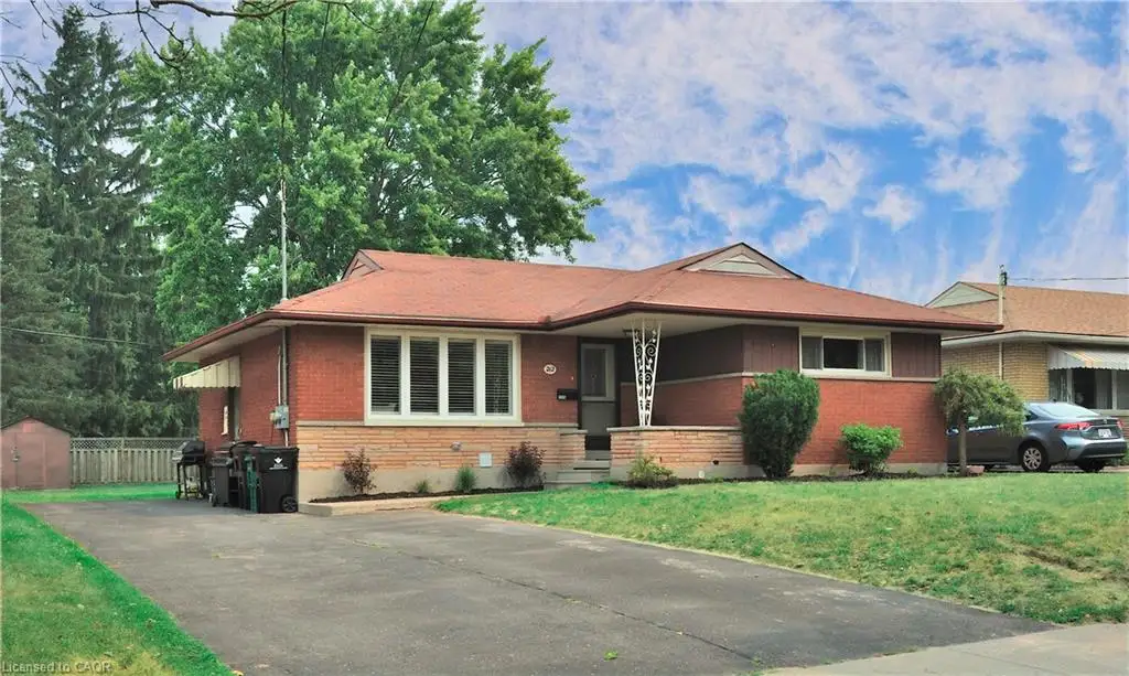 Single-story brick residence with an asphalt driveway and a red-brown roof