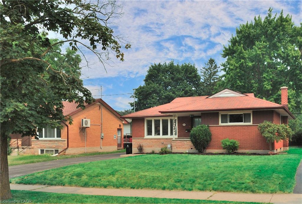 Brick exterior residence featuring a front lawn and paved driveway