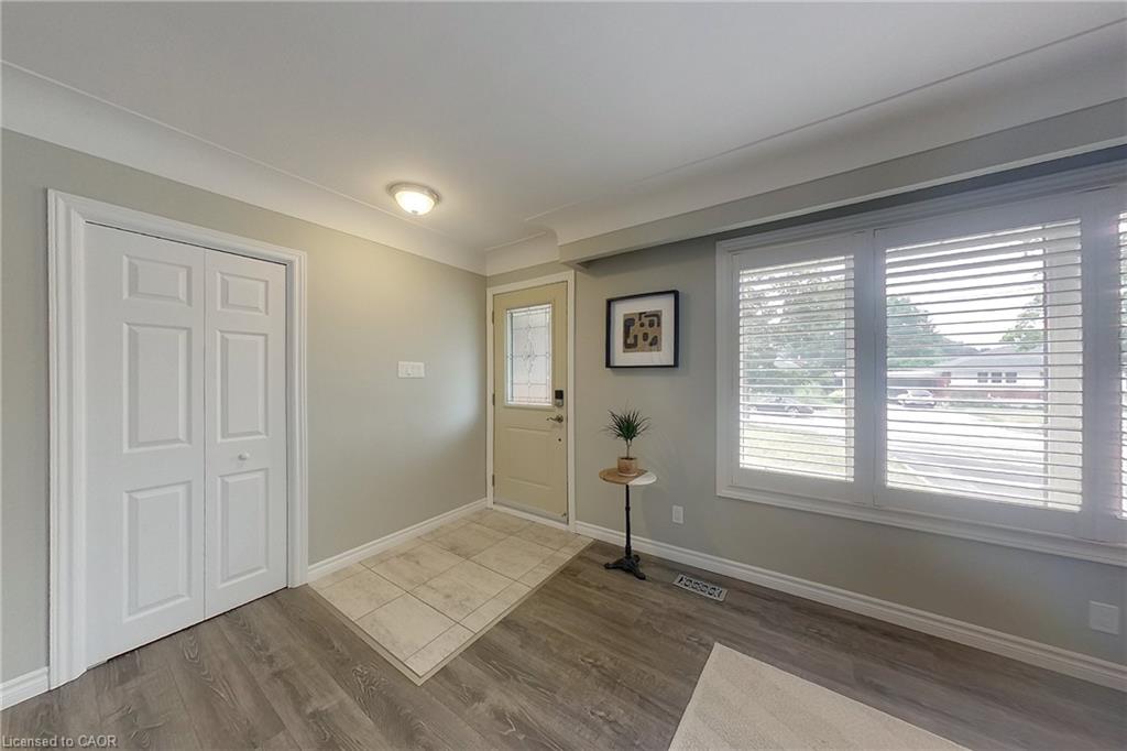 Inviting entryway featuring wood-finish flooring, a bi-fold closet, and a light-toned exterior door with decorative glass