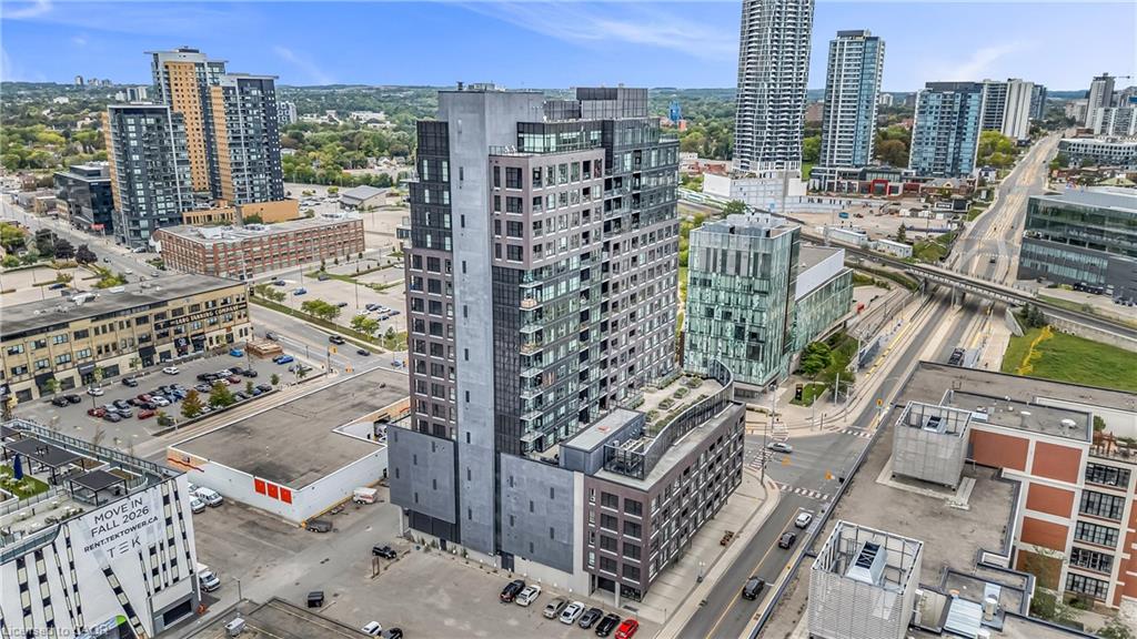 Modern high-rise building featuring a multi-story base, a rooftop terrace, and a prominent glass and panel facade