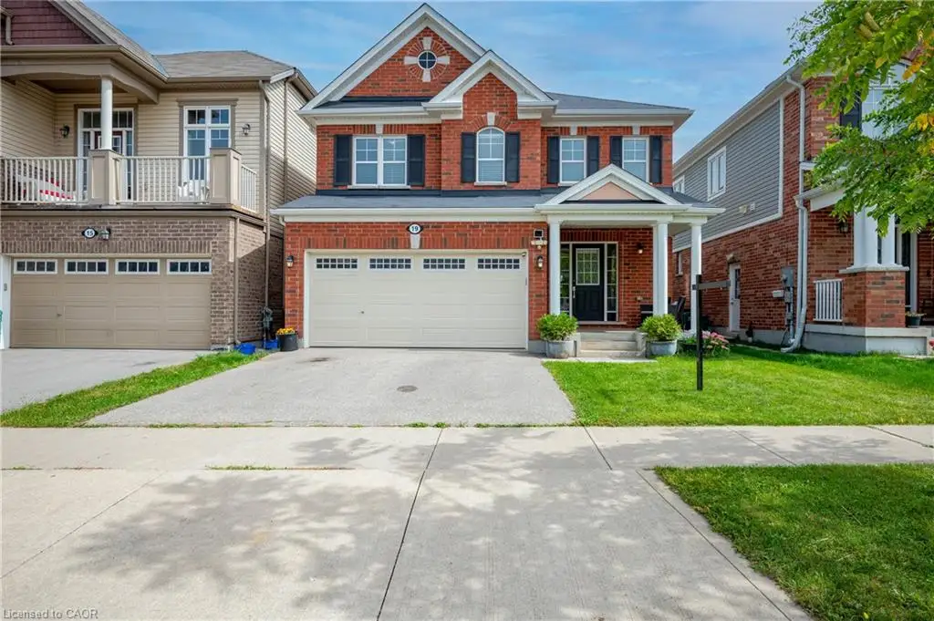 Brick exterior with contrasting shutters, covered front entry, attached two-car garage, concrete driveway, and a manicured lawn