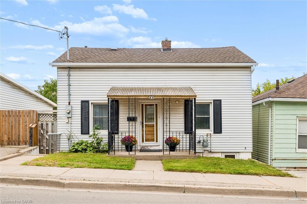 White siding exterior with a covered front porch featuring decorative metal railings