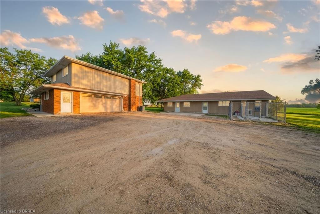 This property includes a two-story building featuring brick and siding exteriors, a garage, and a separate single-story building with a siding exterior and a fenced area