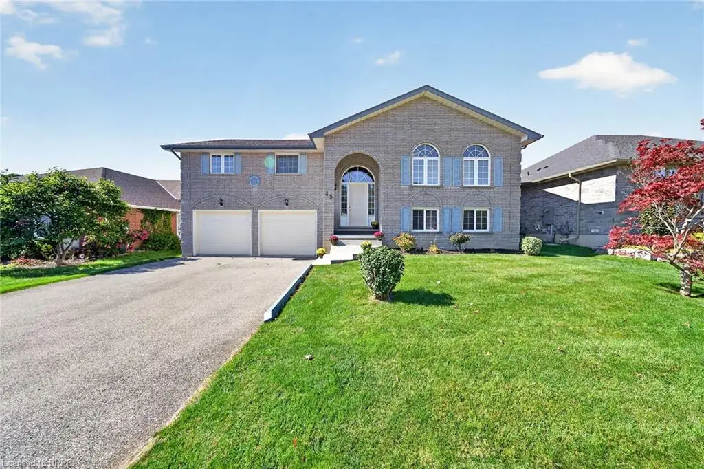 Brick exterior with arched entry, dual garage doors, and a paved driveway