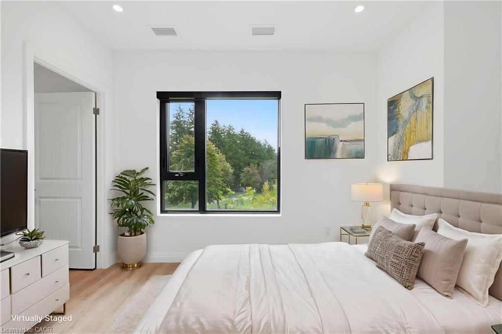 Spacious room featuring a large black-framed window, recessed lighting, and light wood-finish flooring