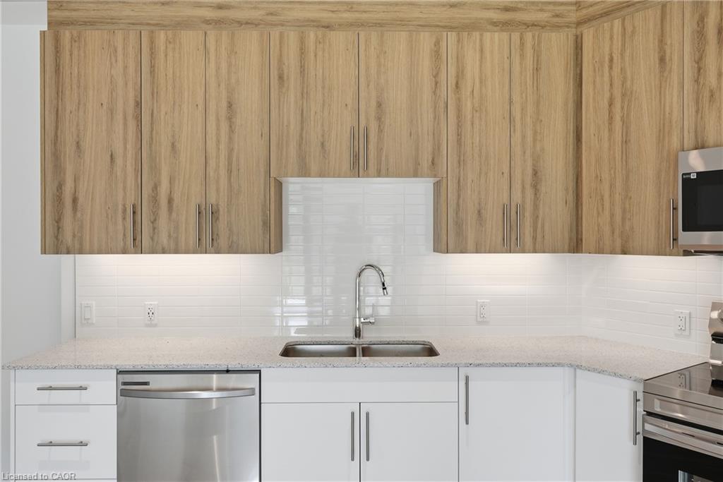 Contemporary kitchen featuring wood-look upper cabinetry, white lower cabinetry, and stainless steel appliances