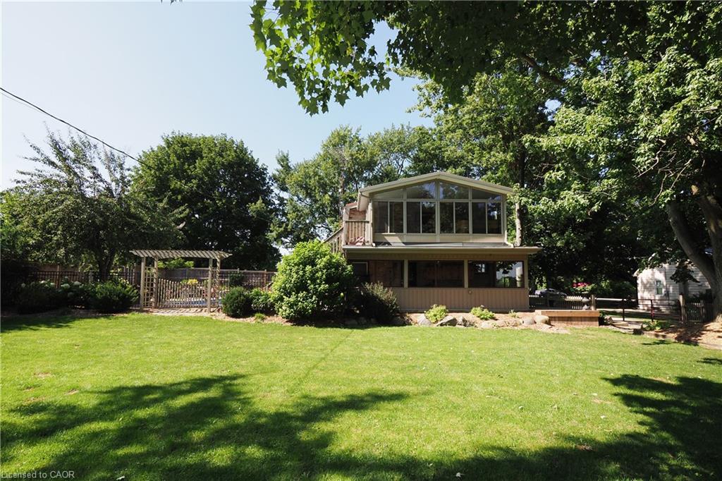 Expansive backyard featuring a manicured lawn and mature trees
