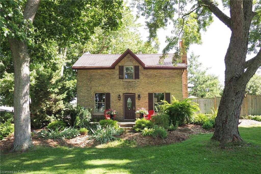 Brick exterior with dark brown window shutters and a matching front door