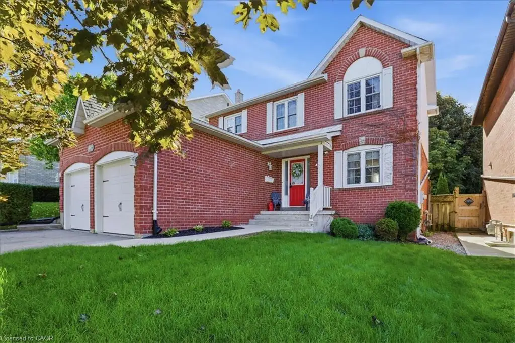 Two-story brick exterior featuring a double-car garage, arched entryways, and a covered front porch