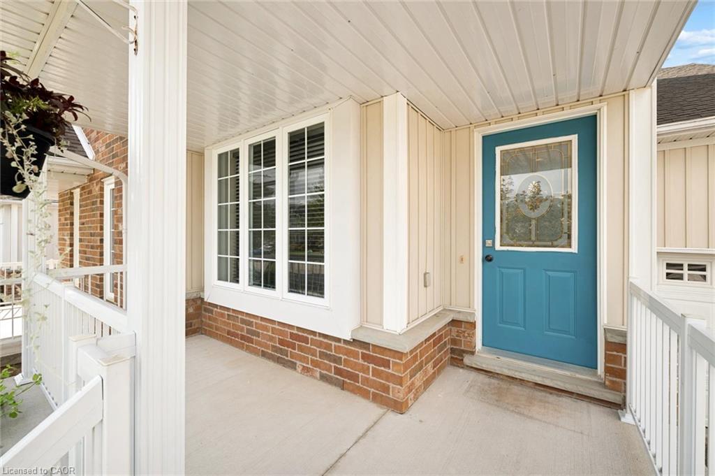 Front entry with a teal paneled door, decorative glass insert. and bay window