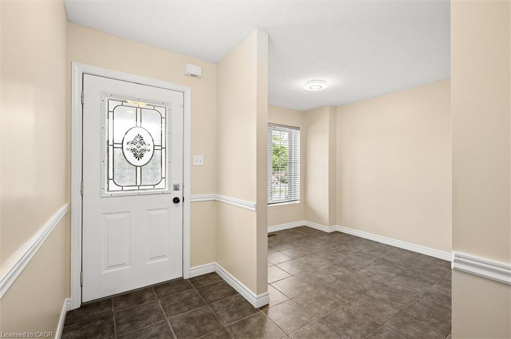 Entryway featuring a decorative glass door, tile flooring, and neutral wall tones