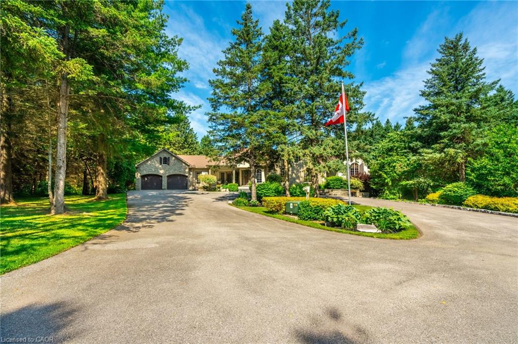 View of front of property featuring a front yard, driveway, and an attached garage