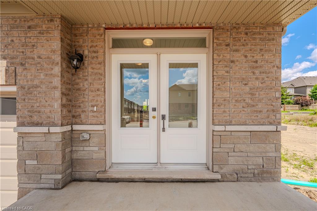 Double entry doors with transom window, brick and stone exterior