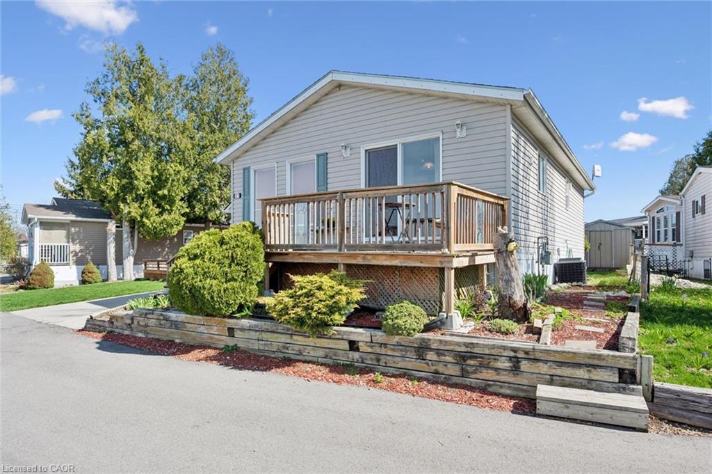 Light gray siding exterior with a wood deck featuring a lattice skirt