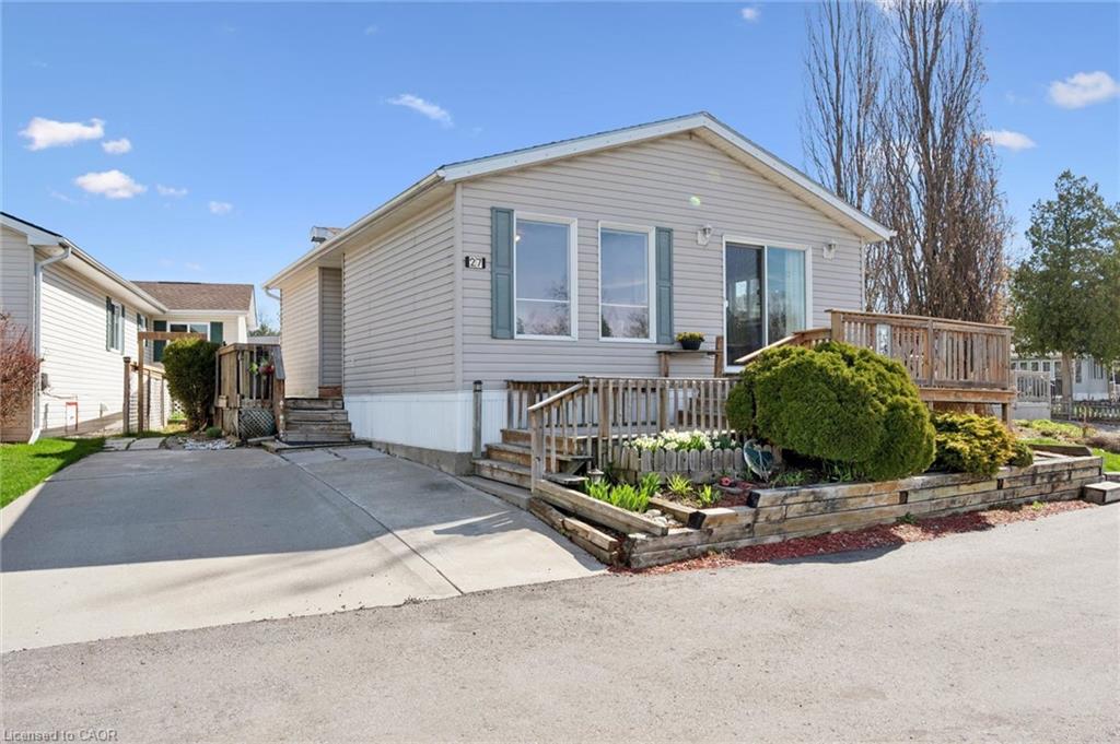 Siding exterior with a front deck featuring wooden railings and steps