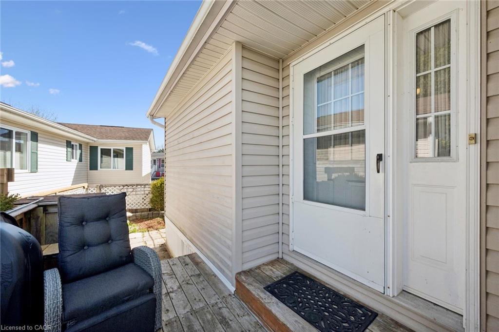 Front entrance with a white storm door and main entry door, featuring a side window pane