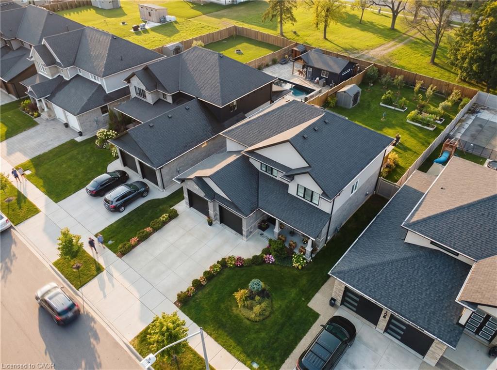 Contemporary residential property featuring an attached two-car garage, concrete driveway, and landscaped front yard