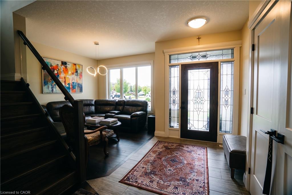 Entryway featuring a dark wood-finish door with intricate glass panels and sidelights, complemented by a transom window