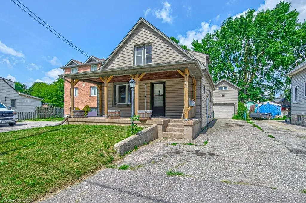 Detached garage. Siding exterior with a covered porch, wood posts, concrete steps, and an attached garage with a paved driveway